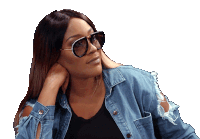 a woman wearing sunglasses and a denim shirt looks to the side