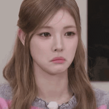 a close up of a woman 's face making a sad face