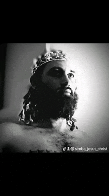 a man with a beard and a crown on his head is a statue of jesus .