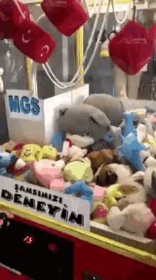 a machine filled with stuffed animals has a sign that says mgs on it