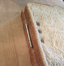 a piece of bread with screws in it on a table