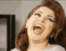 a woman is making a funny face with her mouth open .