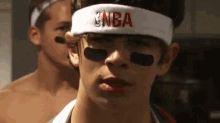 a man wearing a headband with the nba logo on it