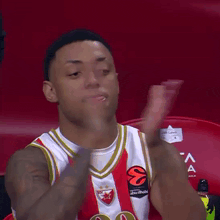 a man wearing a red white and gold jersey with the number 20 on it