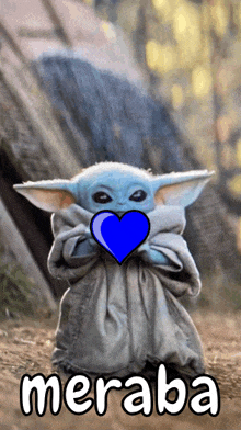 a baby yoda holding a blue heart with the word meraba written below it