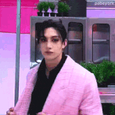 a man wearing a pink jacket and a black shirt is standing in front of a sign that says pabeyork