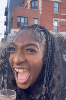 a woman in a fur coat is laughing with her mouth open