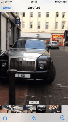 a rolls royce is parked on the side of a street