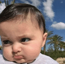 a baby girl is making a funny face with her tongue out .