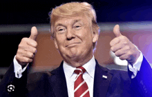 donald trump is giving a thumbs up and smiling