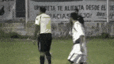 two soccer players are standing in front of a sign that says " un deta te alienta desde el "