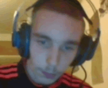 a blurry picture of a man wearing headphones and a red shirt