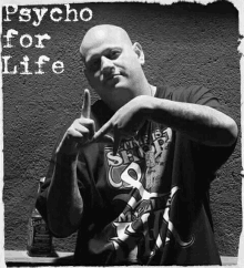 a man in a psycho for life shirt is making a hand sign