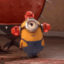 a yellow minion with red boxing gloves and a red hat