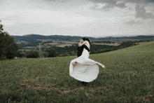 a man holds a woman in his arms in a field