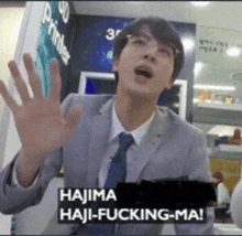 a man in a suit and tie is saying hajima haji fucking ma