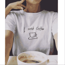 a person wearing a white shirt that says " i need coffee "