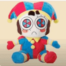 a stuffed clown with a sad face is sitting on a yellow surface .