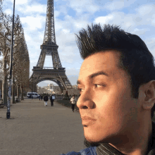 a man standing in front of the eiffel tower in paris