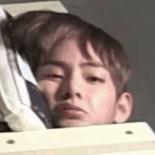 a close up of a young boy making a funny face while sitting in a chair .