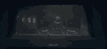 a dark room with the word woah on the bottom right