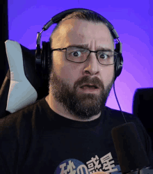 a man with a beard wearing headphones and a black shirt with chinese writing