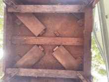 the bottom of a wooden table has a few pieces of wood missing