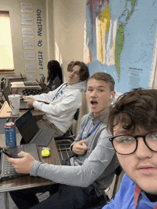 a group of young men are sitting at desks in front of a map that says " north atlantic ocean "