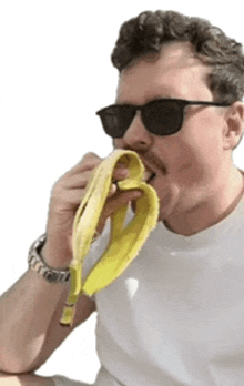 a man wearing sunglasses and a watch is eating a banana