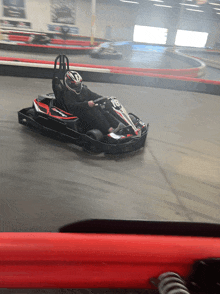 a person driving a go kart on a track with a helmet on