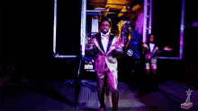 a man in a suit is dancing in front of a car