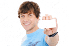 a man in a blue shirt is holding up a white card