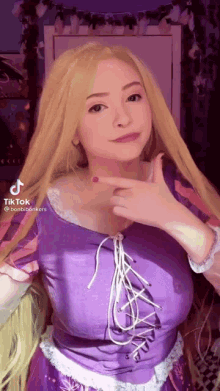 a woman with long blonde hair is wearing a purple dress