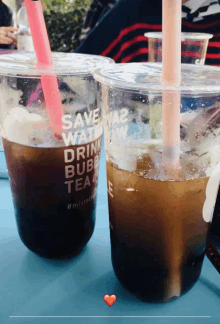 two cups of bubble tea with pink straws and the words save water drink bubble tea