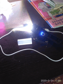 a flashlight is being charged on a table in front of a book that says " большие для детей "