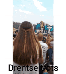 a woman with braided hair is sitting in front of a crowd with the words drentse trots written on the bottom