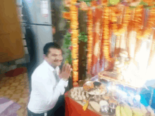 a man is standing in front of a display of flowers and food