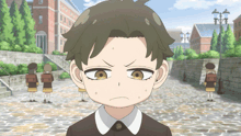 a boy with a serious look on his face is standing on a cobblestone street