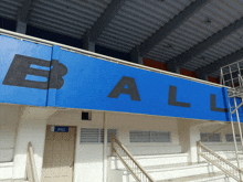 the word ball is on a blue sign above the stairs