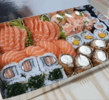 a box filled with sushi and salmon slices