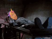 a cartoon character with a unicorn horn is laying on a table with his feet up .