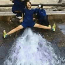 a woman is sitting on the ground with her legs crossed and a stream of water is coming out of her butt .