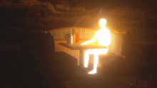 a silhouette of a person sitting at a table with a light behind them