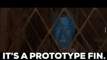 a man with blue paint on his face is behind bars with the words `` it 's a prototype fin '' written below him .