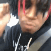 a close up of a person 's face with red hair and a black hoodie .