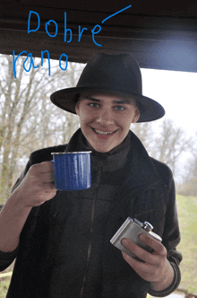 a man in a hat is holding a blue mug and a flask with the word dobre written on it