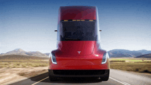 a tesla semi truck is driving down a road