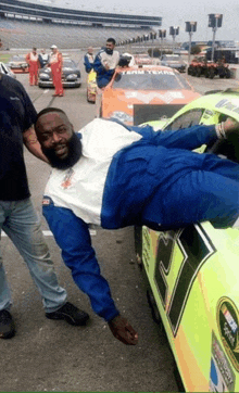 a man is laying on the side of a race car with the number 21 on the side