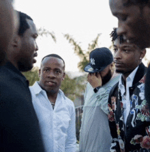 a man wearing a ny hat is talking to another man