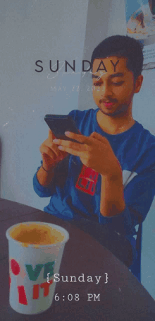 a man sits at a table with a cup of coffee and a phone